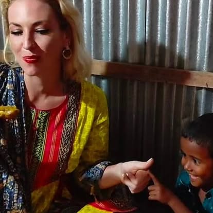 Alizah laughing with a young child during community work in India